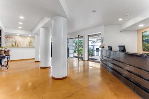 an empty living room with white columns and wood floors at Whispering Palms Beach Resort in Candolim
