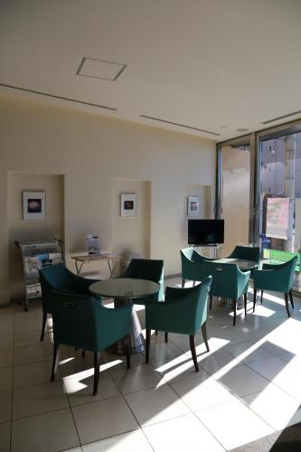 a room with tables and chairs and a television at Hotel Plaza Arakawaoki in Tsuchiura