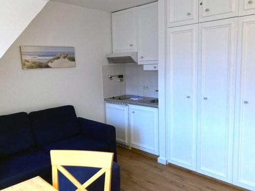 un soggiorno con un divano blu e una cucina di Inselresidenz Strandburg Juist FeW a Juist