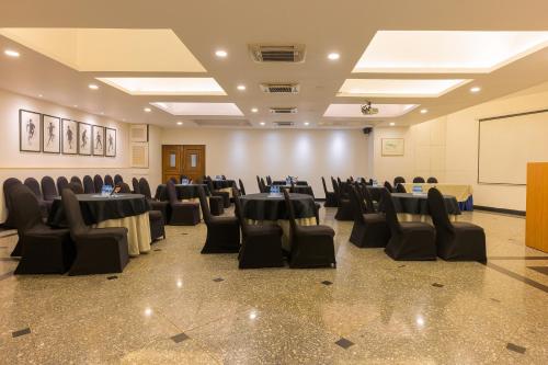 a banquet hall with tables and chairs in a room at Whispering Palms Beach Resort in Candolim