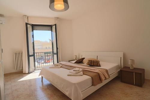 a bedroom with two beds and a large window at Holiday house Idrusa in Otranto in Otranto