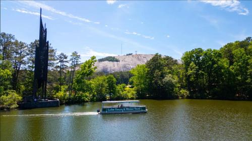 a boat on a river with a mountain in the background at Atlanta Evergreen Lakeside Resort in Stone Mountain