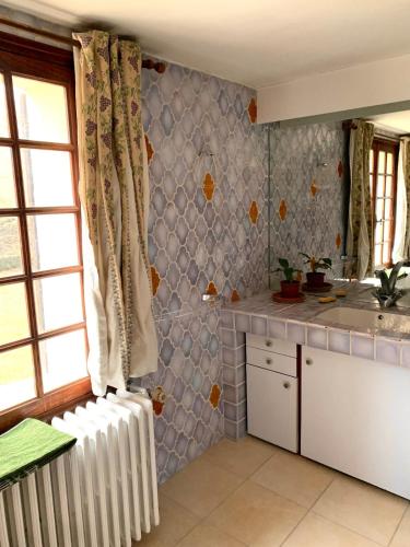 une cuisine avec un radiateur blanc dans une pièce dans l'établissement Les Favouilles, le gîte pour 15 personnes, à Dauphin