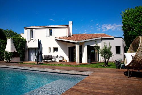 une maison avec une piscine devant une maison dans l'établissement Villa avec piscine au charme authentique et naturel, à Baillargues