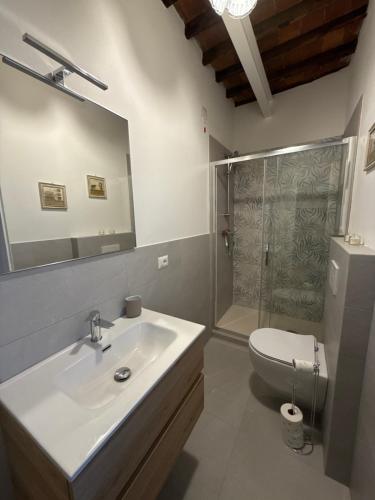 a bathroom with a sink and a toilet and a mirror at La Casa al Castello in Lucca