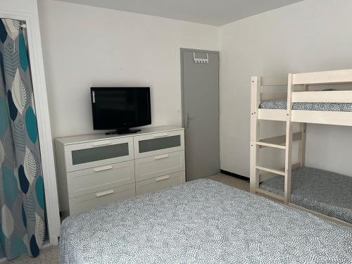 - une chambre avec une télévision et des lits superposés dans l'établissement Le Fenouil, au Grau-du-Roi