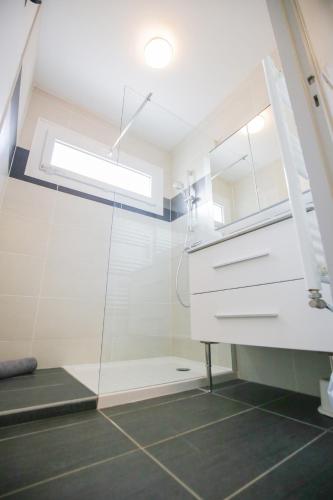 une salle de bain avec un lavabo et une douche dans l'établissement Le Fenouil, au Grau-du-Roi