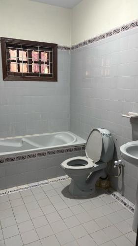 a bathroom with a toilet and a bath tub at Hotel Heavenly Stays in Karachi