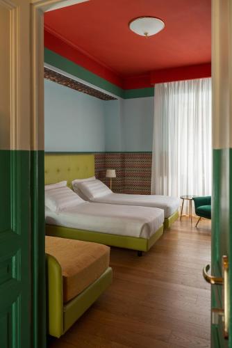zwei Betten in einem Zimmer mit roter Decke in der Unterkunft Hotel Oceania in Rom