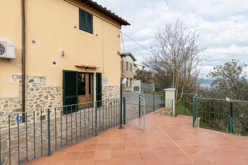 a house with a fence and a balcony at GuestHost - Lovely Apt with Panoramic Terrace in Carmignano