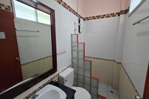 a bathroom with a toilet and a sink and a mirror at KhiangLe Resort 1 in Songkhla