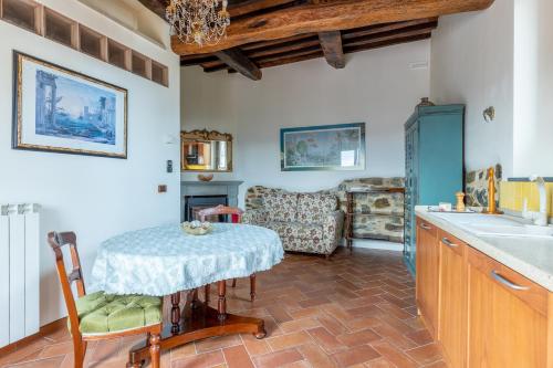 a kitchen with a table and a living room at GuestHost - Lovely Apt with Panoramic Terrace in Carmignano
