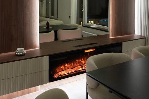 a fireplace in a room with chairs and a table at SkySpa Apartments - апартаменти з джакузі на терасі з видом на Печерськ in Kyiv