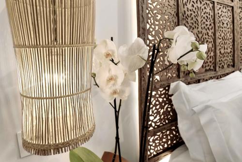 a vase filled with white flowers next to a wall at Hotel La Casa de Los Mosaicos by Maxi Hoteles in Granada