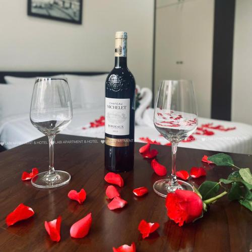a bottle of wine and two wine glasses on a table at LaBi Hotel n Apartment Danang in Da Nang