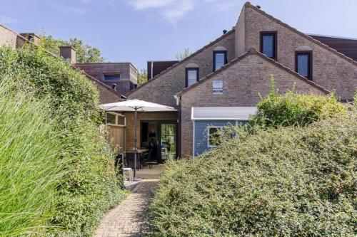 a brick house with a pathway leading to the front door at Spaanse Galeien 16 in Retranchement