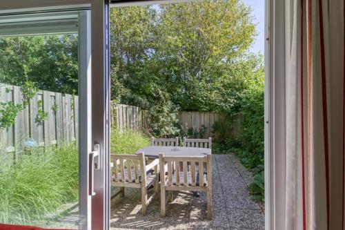 a sliding glass door with a table and bench outside at Spaanse Galeien 16 in Retranchement