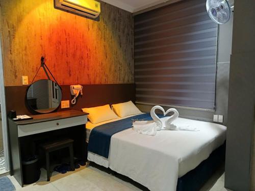 a bedroom with a bed with a desk and a tv at Japan Luna Hotel in Dĩ An