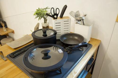 a stove top with a pot and pans on it at アーモンド石垣 in Tunugusuku