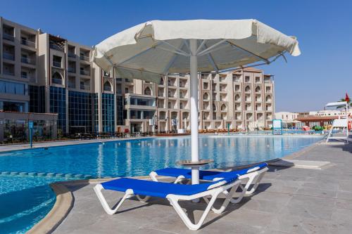 a lounge chair with an umbrella next to a swimming pool at Sunrise Alora Aqua Park Resort in Hurghada