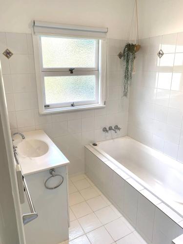 a white bathroom with a tub and a sink at Abasea You'll love it in Byron Bay