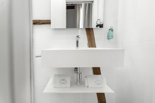 a white bathroom with a sink and a mirror at Hotel La Casa de Los Mosaicos by Maxi Hoteles in Granada