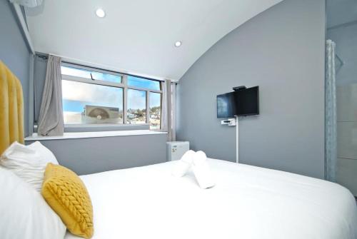 una camera da letto con un letto bianco e una finestra di City view lodge a Città del Capo