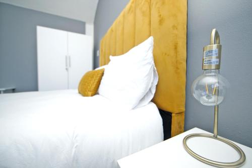 una camera con un letto bianco e una testiera gialla di City view lodge a Città del Capo
