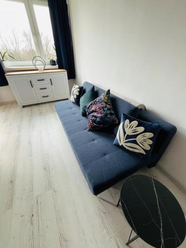 a blue couch with pillows in a living room at Comfortable one bedroom apartment in Świdnik
