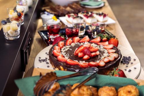 een tafel met een chocoladetaart met aardbeien erop bij Nomadic Urban Premium Suites in Krakau