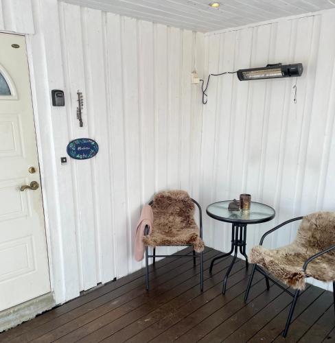 a room with a table and two chairs and a door at Marvelous farmhouse with WiFi in Troms, Northern Norway in Nordøya