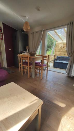 un salon avec une table et une salle à manger dans l'établissement MH Les Mimosas sur terrain privé en pinède La Tranche Sur Mer, à La Tranche-sur-Mer