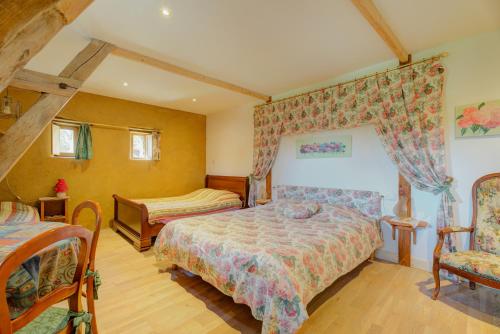 a bedroom with two beds and two chairs in it at Au fournil de L'essart in Boisgervilly