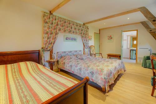 a bedroom with two beds in a room at Au fournil de L'essart in Boisgervilly