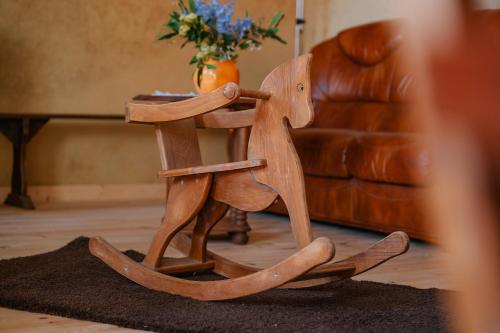 a wooden rocking horse in a living room at Au fournil de L'essart in Boisgervilly
