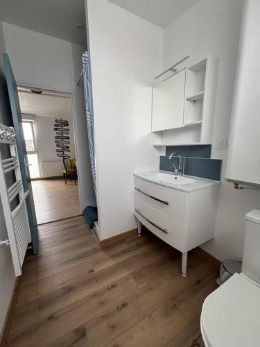 une cuisine blanche avec un évier et des toilettes dans l'établissement Maison avec terrasse, 10 couchages, à 200 m de la plage, à Berck-sur-Mer