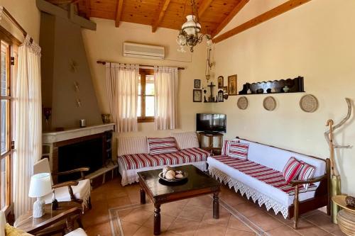 a living room with two couches and a tv at Finikounta Sunset Family Maisonette in Grizókambos