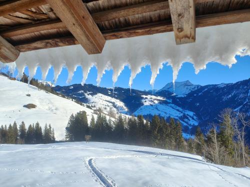 a group of icicles hanging from a roof over a snow covered mountain at Mountain Village Room in Habkern