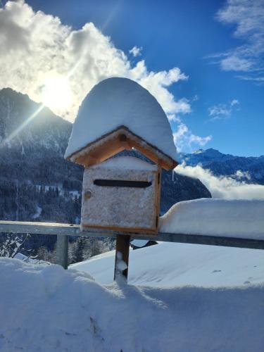 a bird house covered in snow on a fence at Mountain Village Room in Habkern
