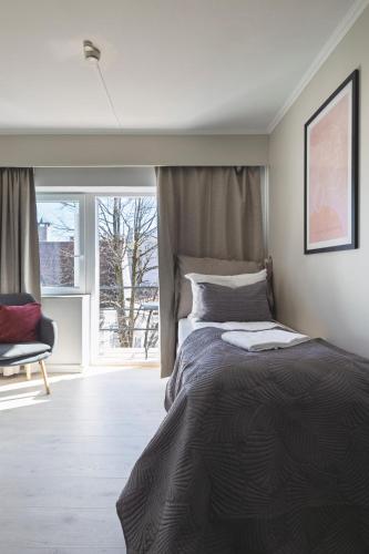 a bedroom with a large bed and a window at Victoria hotell & apartments Fredrikstad in Fredrikstad