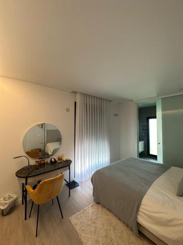a bedroom with a bed and a desk with a mirror at Villa NewRay in Finestrat