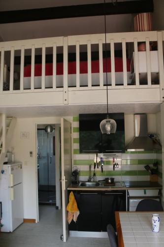 - une cuisine avec un évier sous une mezzanine dans l'établissement Les Capellans, port d'attache, à Saint Cyprien Plage