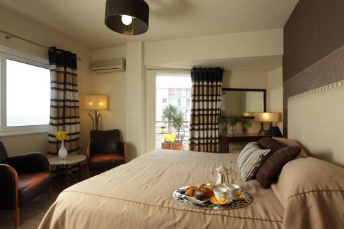 a bedroom with a bed with a tray of food on it at Mati Hotel in Mati