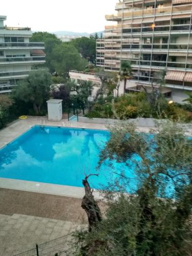 une piscine bleue en face d'un bâtiment dans l'établissement Studio Juan les pins, à Antibes