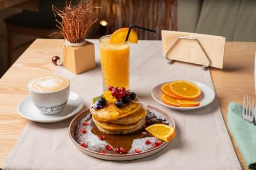 un tavolo con un piatto di pancake e una tazza di caffè di Barrique Brâncoveanu 3 a Braşov