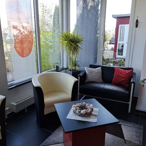 a living room with couches and a table with a bowl on it at Allgäuhotel Memmingen Nord in Memmingen