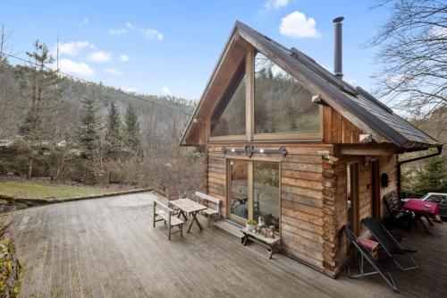 a log cabin with a picnic table on a deck at Srub Pod Lípou - Skryje in Skryje