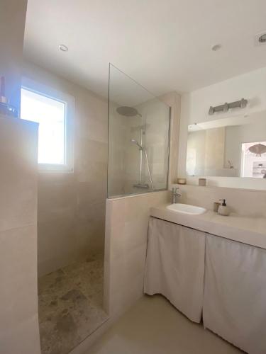 une salle de bain blanche avec un lavabo et un miroir dans l'établissement Logement charmant avec vue magique, à Montauroux