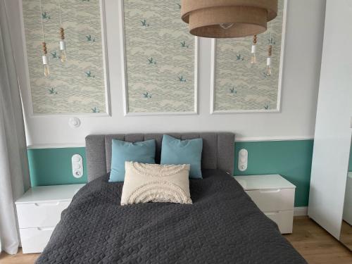 a bedroom with a bed with blue and white at Solaris Darłówko Premium Emilia Strupiechowska in Darłowo