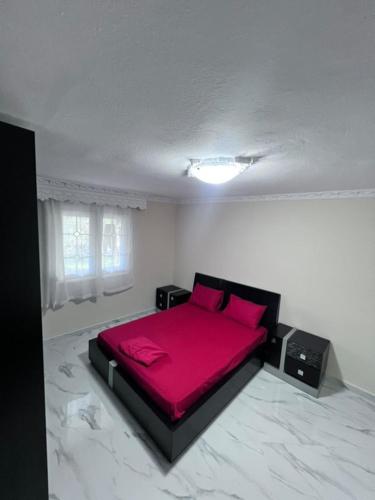 a bedroom with a red bed in a white room at Narcis House in Thessaloniki